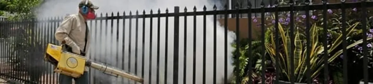 Mosquito control technician fogging a yard perimeter for mosquito reduction in Huntsville, AL